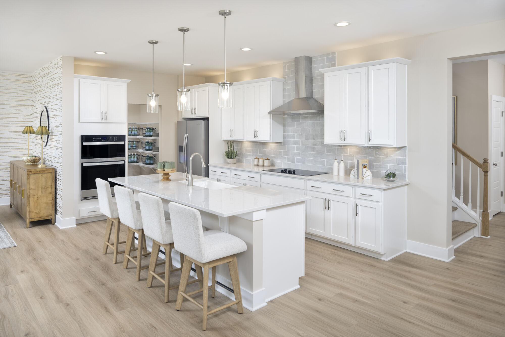 Gourmet kitchen with white countertops and cabinets, island with sink, and stainless steel appliances.