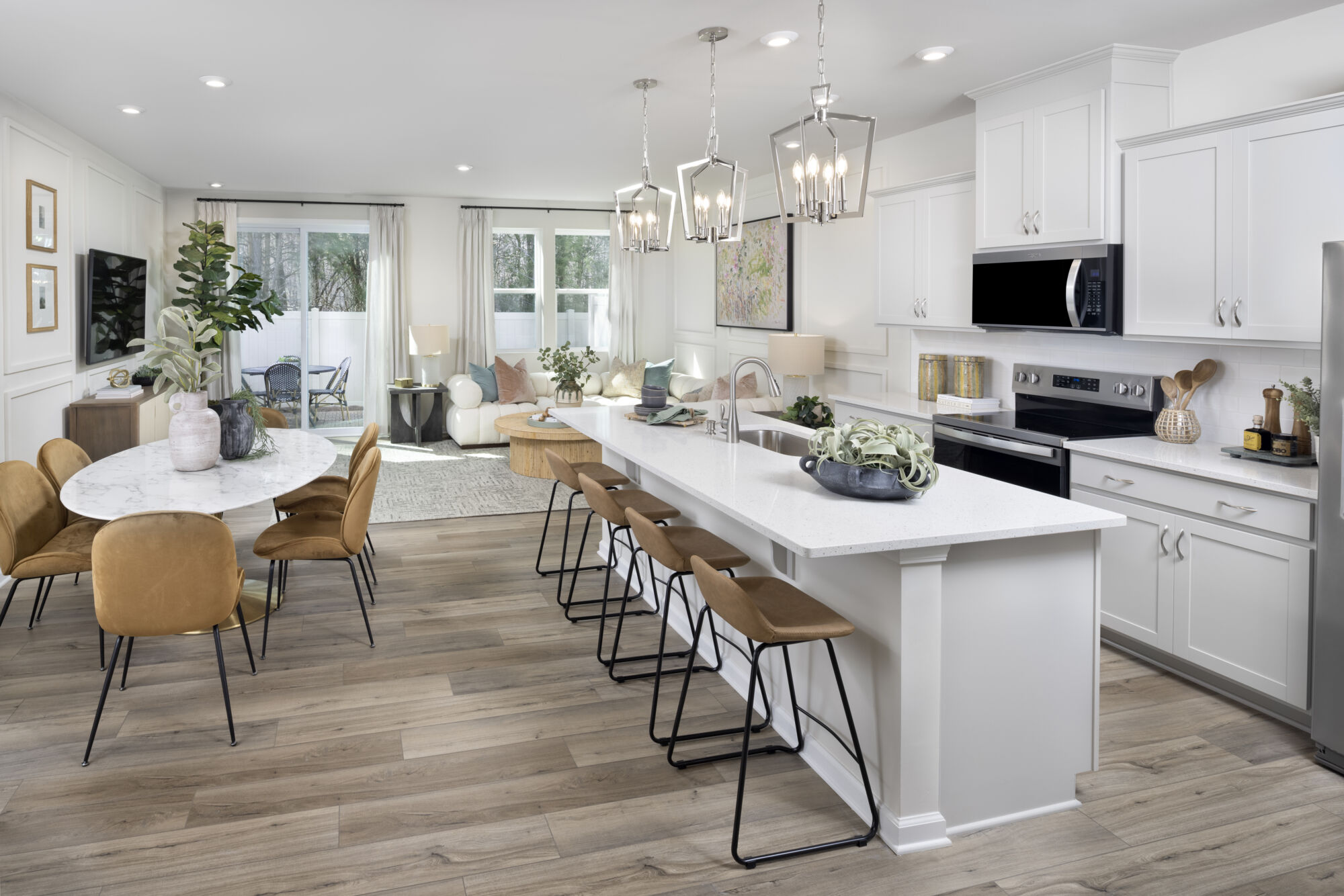  Greatroom with painting, pendant light, white cabinets, window, range, curtains and wood flooring
