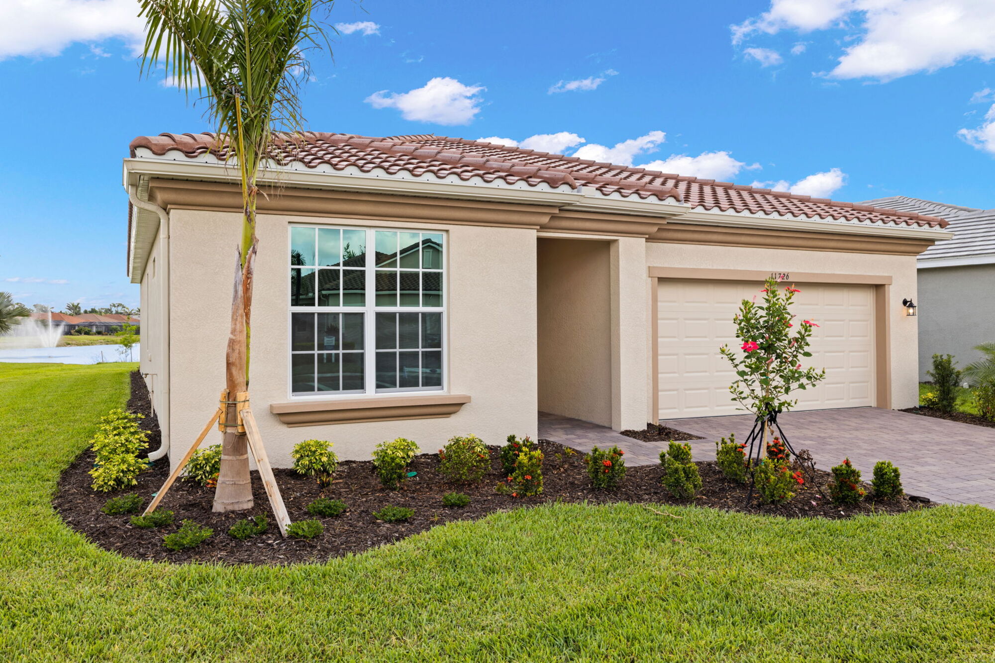 Tile roof, 2 car garage, water lot, double windows, covered front walk, paver driveway, paver front walkway, palm tree, landscaping