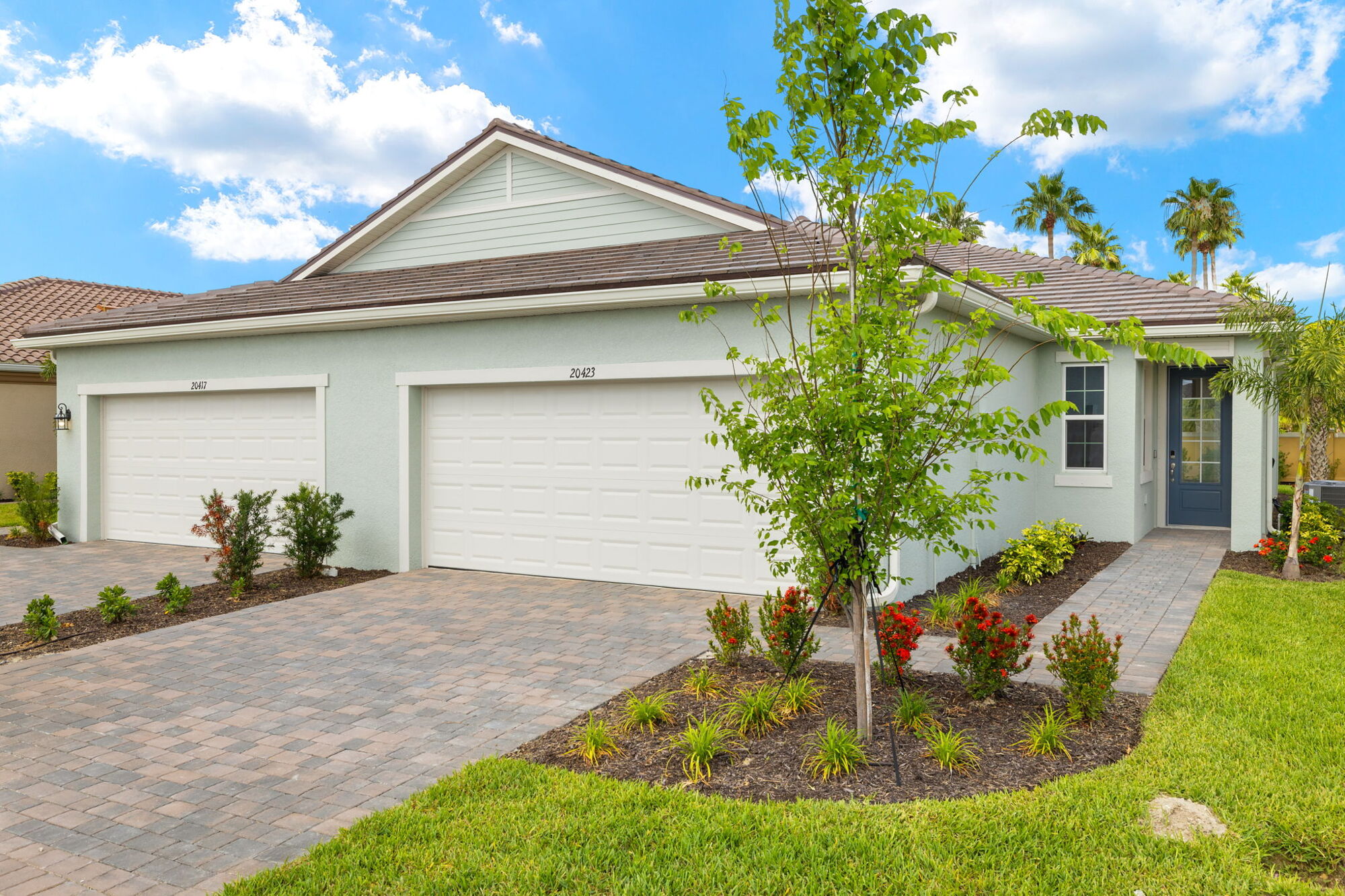 paired villa, 2 bedrooms, 2 baths, 2-car garage, end unit, covered lanai, paver driveway, paver front walk, paver lanai, West Indies exterior