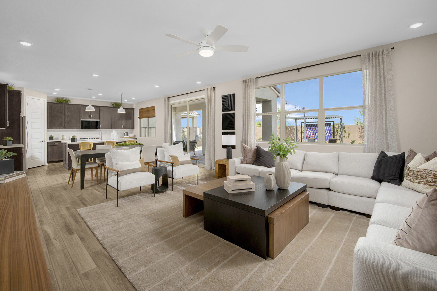 Greatroom with window, curtains, dark wood cabinets, pendant light, door, rug and wood flooring