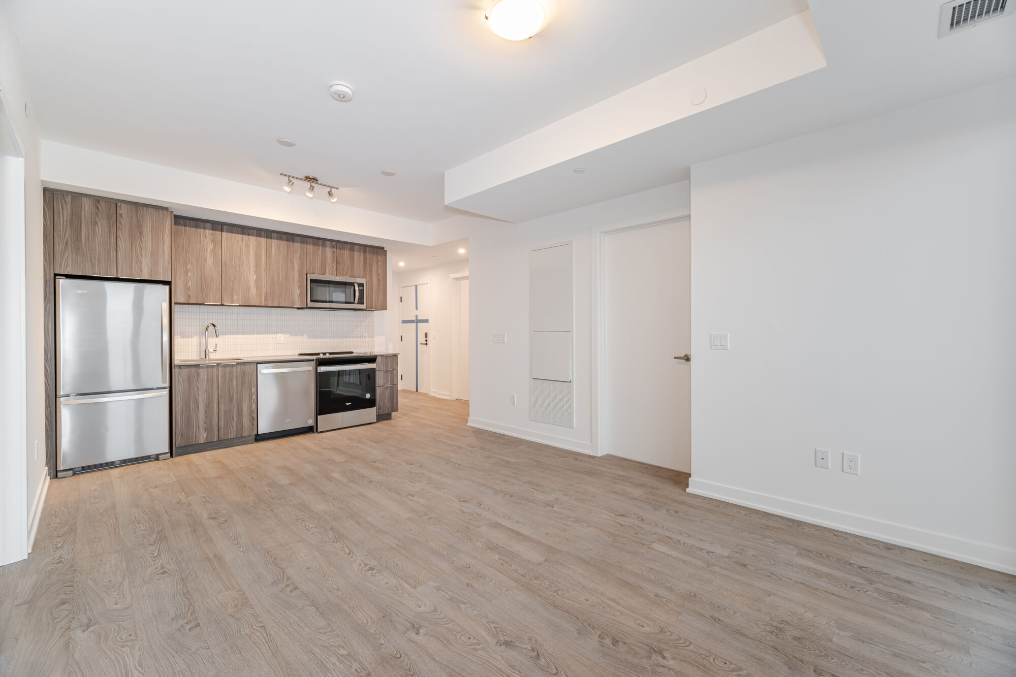 Kitchen with dark wood coloured cabinets, quartz countertop and stainless steel appliances
