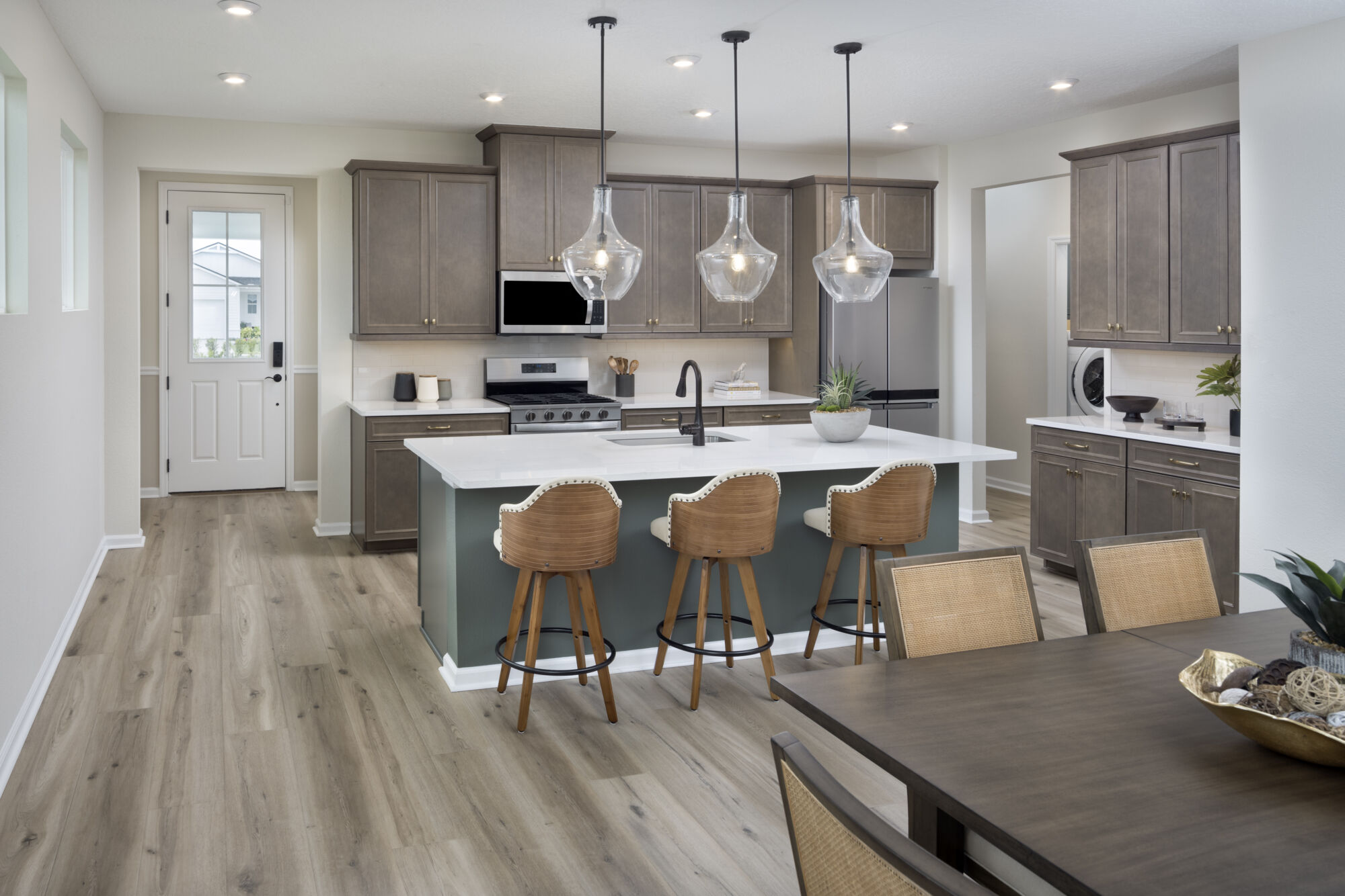 Single-Wall Kitchen with door, range, pendant light, dark wood cabinets, wood flooring and window