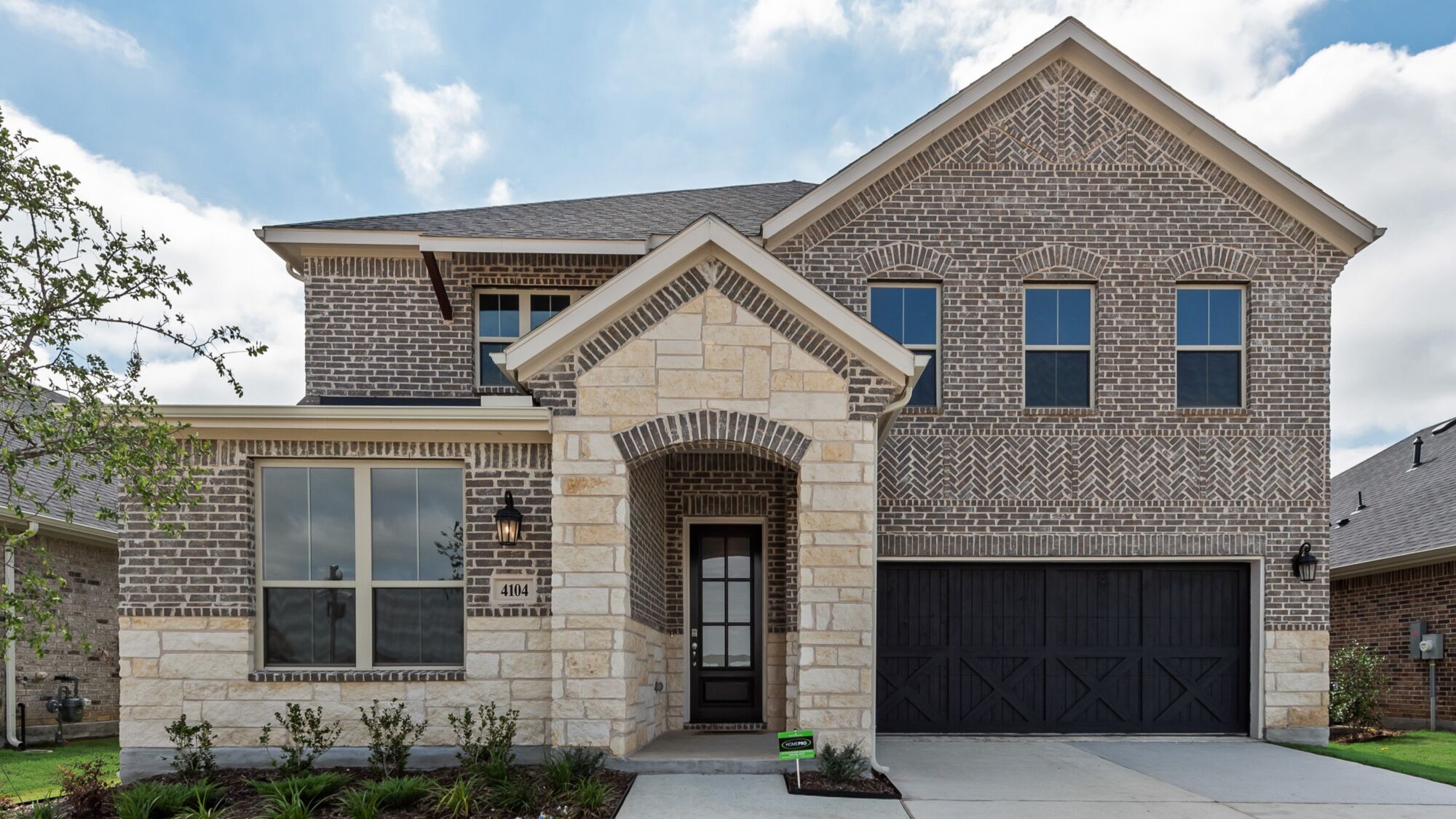 Elevation Front with garage, door, window, exterior stone and exterior brick