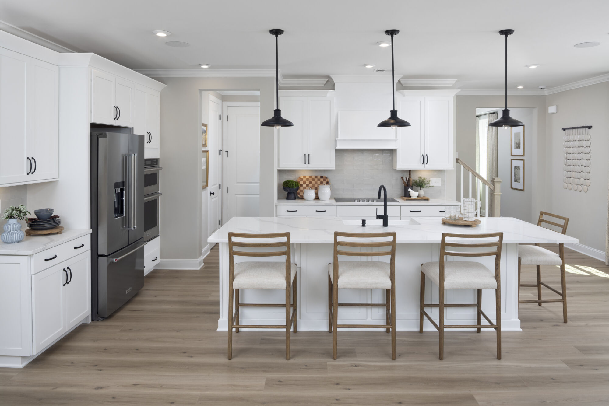 Single-Wall Kitchen with white cabinets, pendant light, painting, door, refrigerator and wood flooring