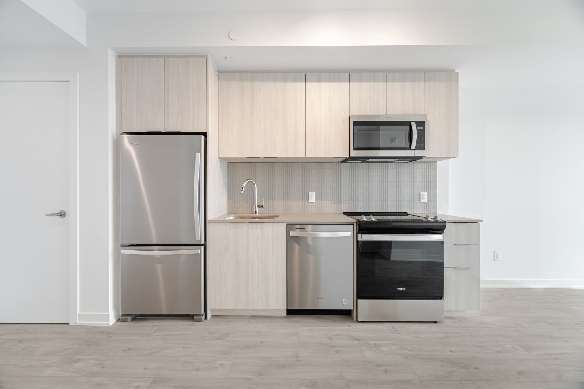 Condo Kitchen with light cabinetry, stainless steel appliances, and quartz countertop