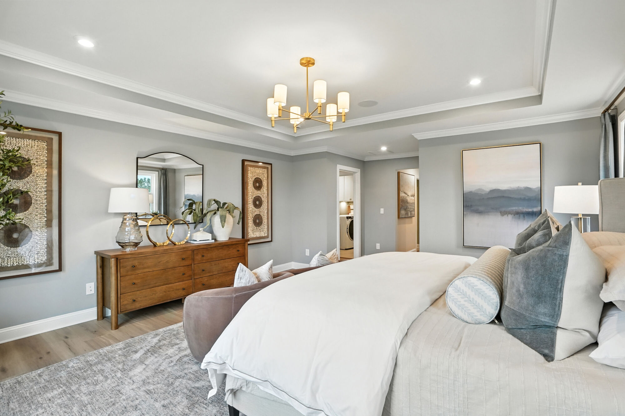 Owners Suite Bedroom with painting, mirror, rug and wood flooring