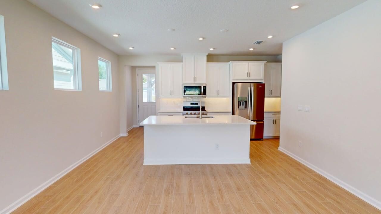 Single-Wall Kitchen with window, refrigerator, white cabinets, door, wood flooring and range
