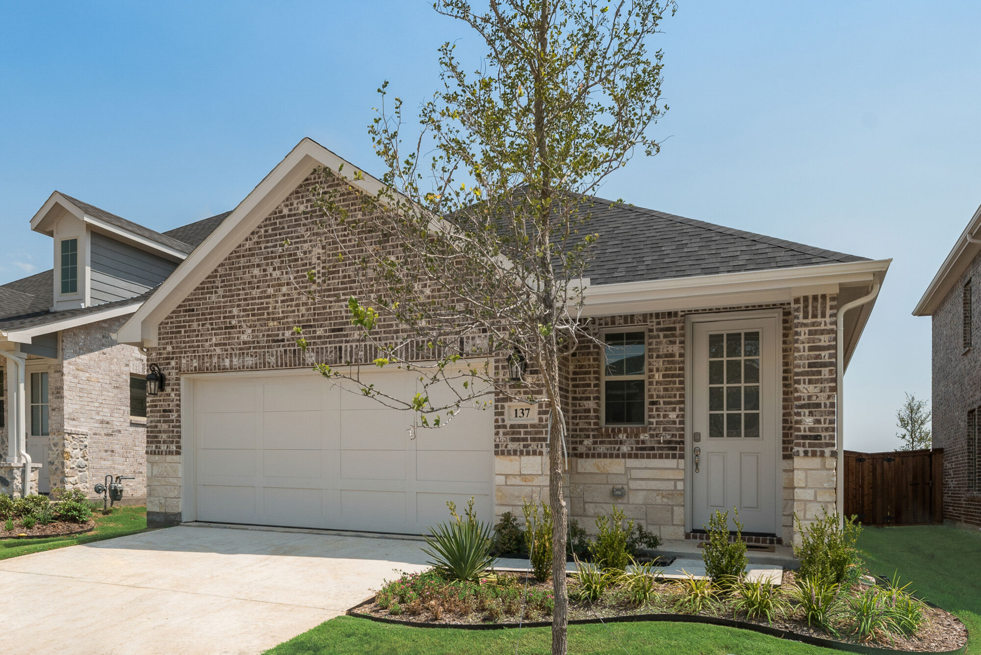 Elevation Front with door, garage, window, exterior stone, exterior brick and exterior clapboard