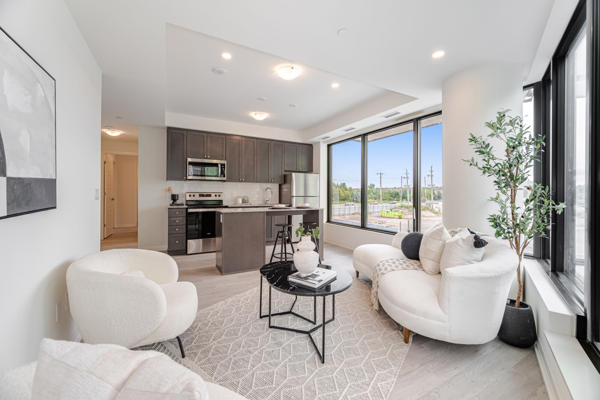 Condo kitchen with dark cabinetry, stainless steel appliances, kitchen island and quartz countertops.