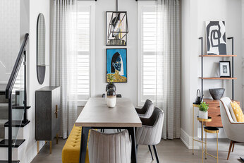 Dining area with rectangular table, grey chairs, and a yellow bench.