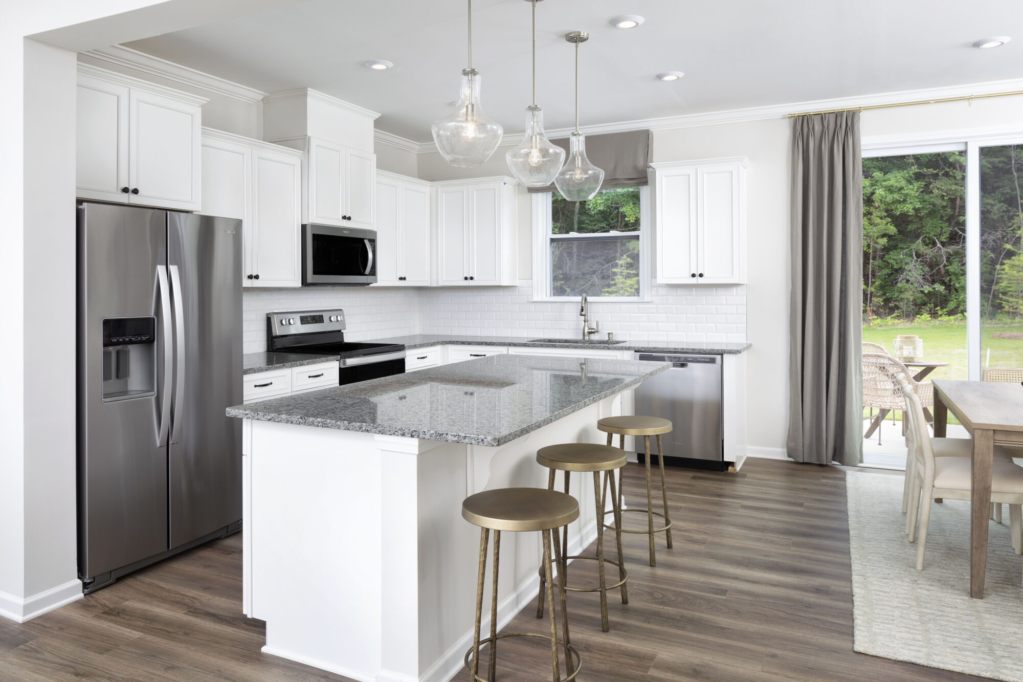 L-Shaped Kitchen with window, refrigerator, curtains, range, pendant light, white cabinets, door, rug and wood flooring