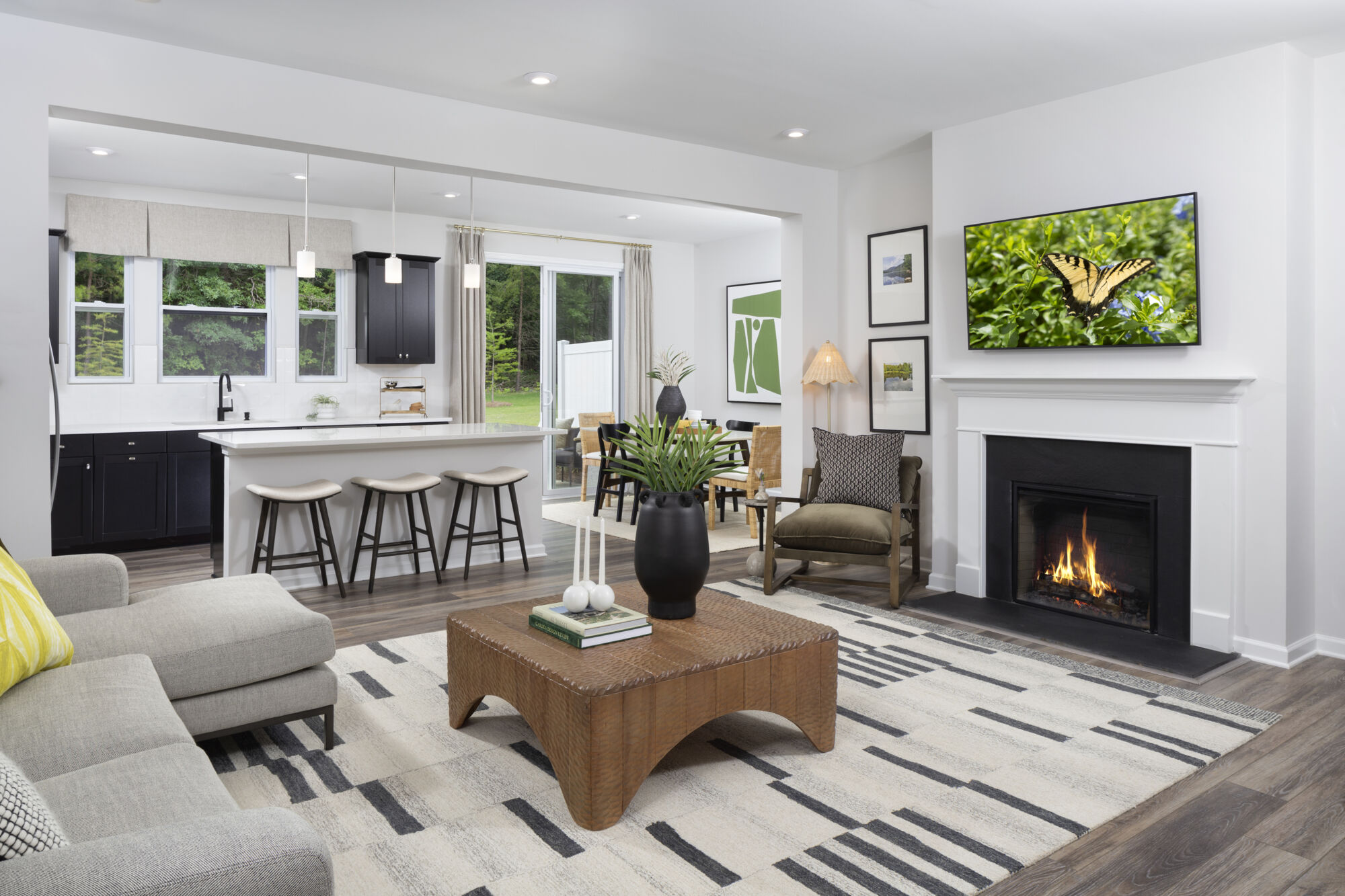  Greatroom with fireplace, window, painting, rug, curtains, wood flooring and pendant light