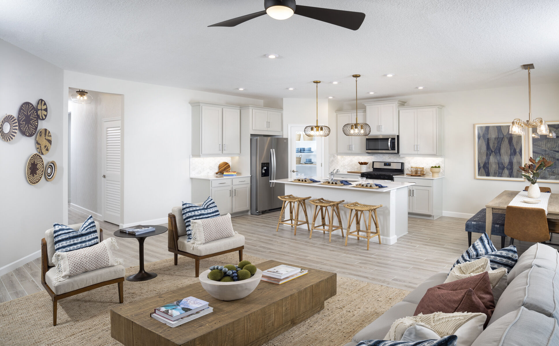  Greatroom with refrigerator, pendant light, painting, door, rug, range, white cabinets, raised panel cabinets and tile flooring