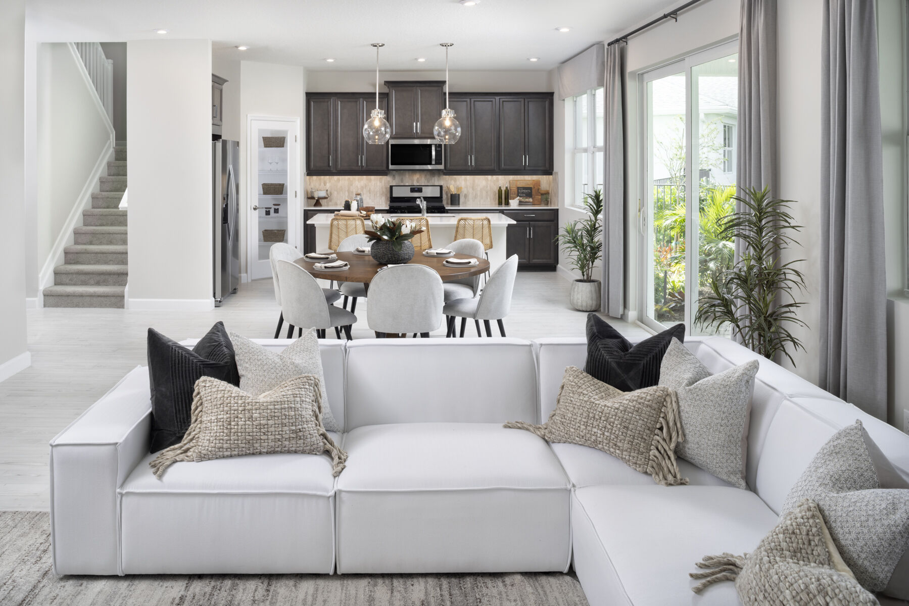  Greatroom with pendant light, curtains, window, door, range and dark wood cabinets
