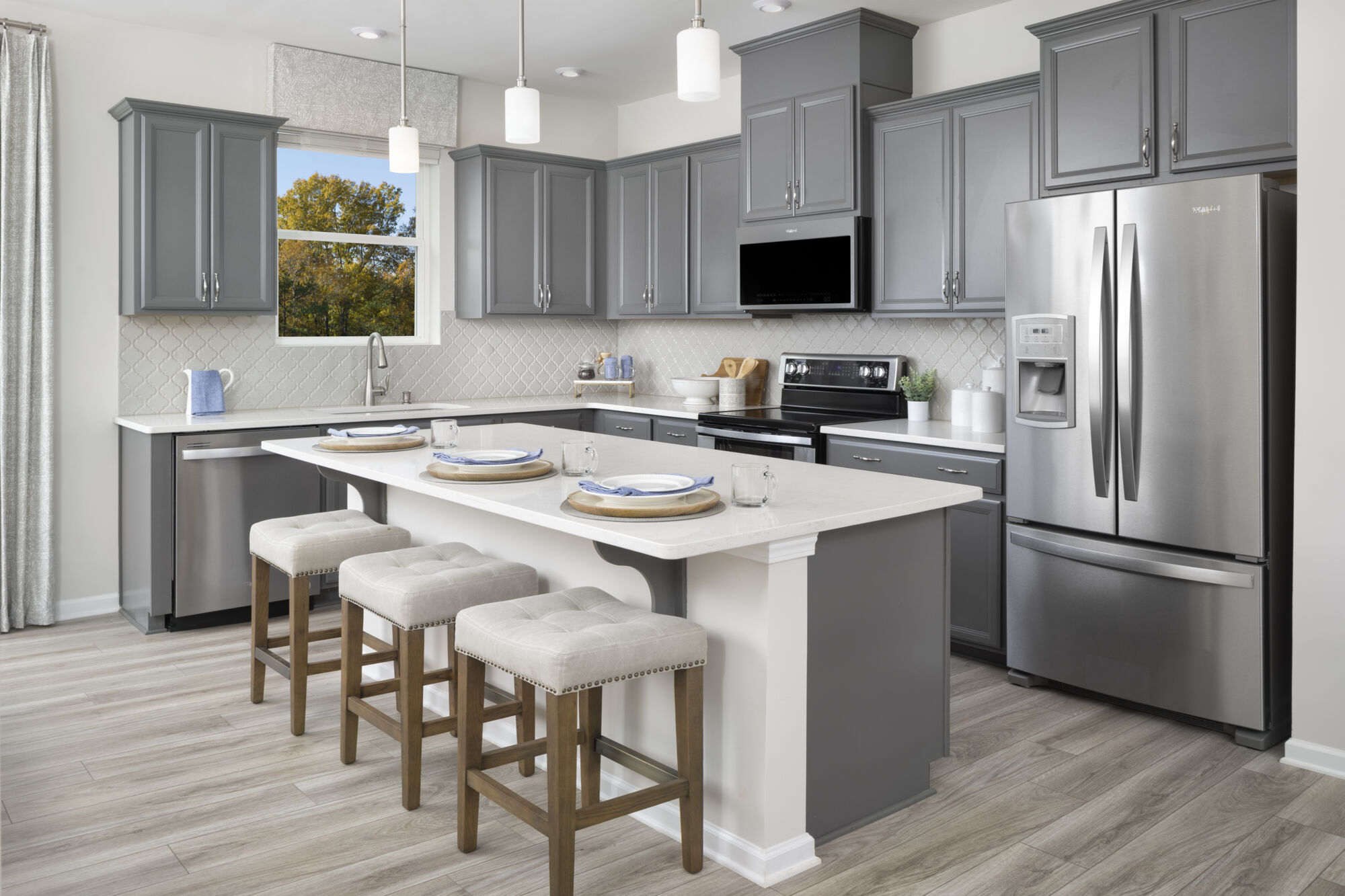 L-Shaped Kitchen with window, refrigerator, pendant light, curtains, range, white cabinets and wood flooring