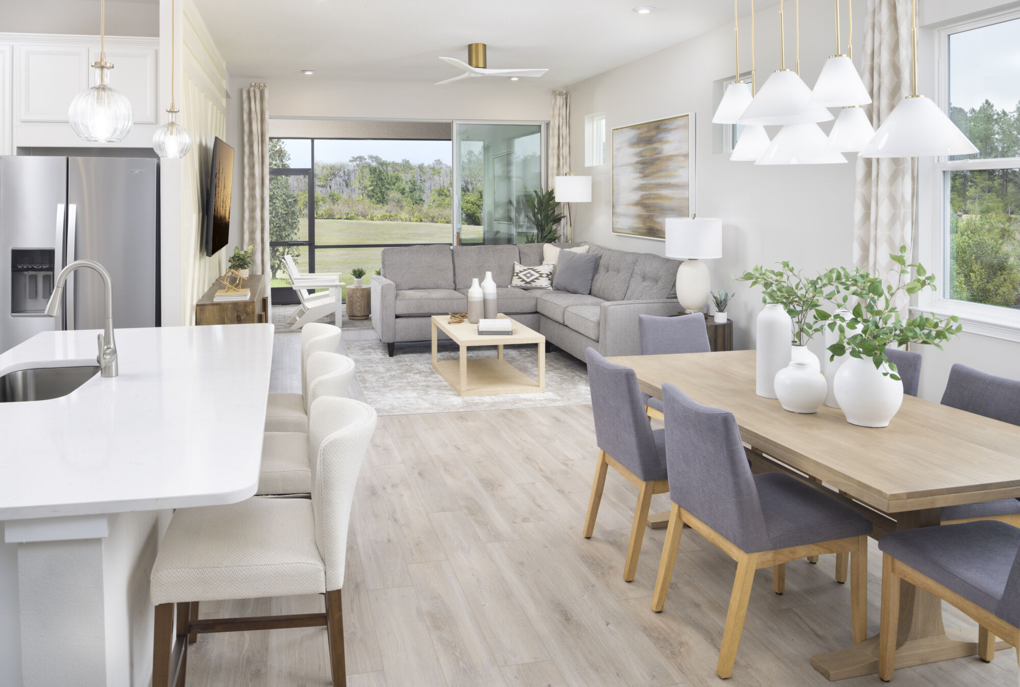  Greatroom with painting, pendant light, refrigerator, window, curtains, white cabinets, door, rug and wood flooring