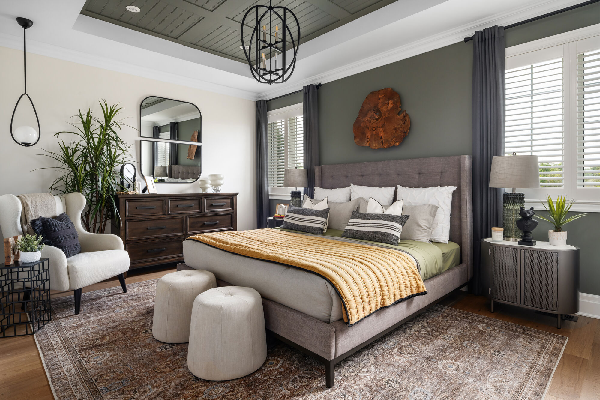 Owners Suite Bedroom with mirror, pendant light, curtains, window, rug and wood flooring
