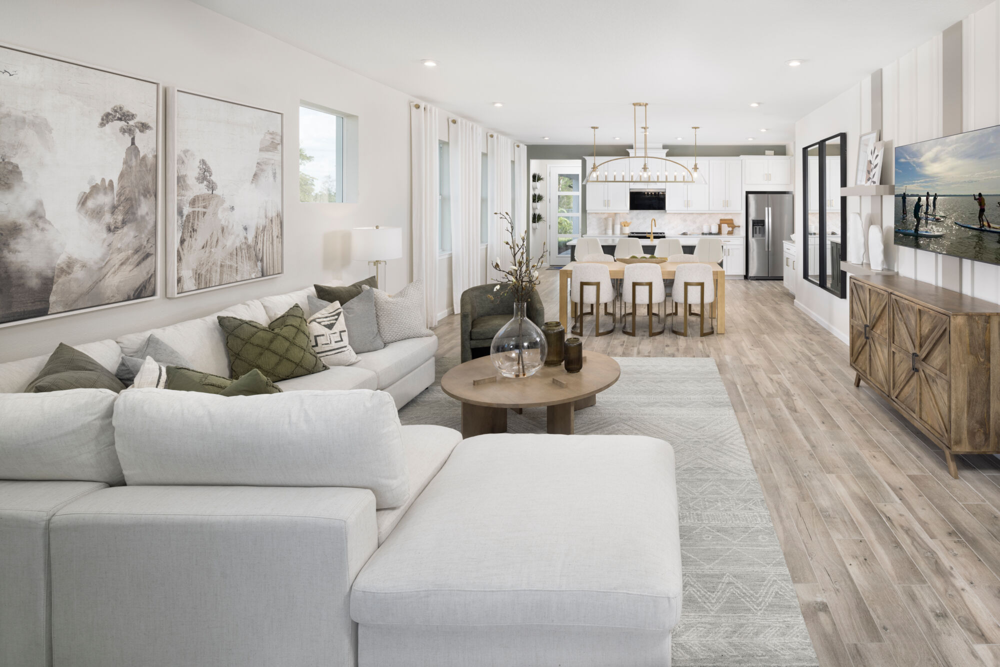  Greatroom with window, painting, refrigerator, curtains, pendant light, door, white cabinets and wood flooring