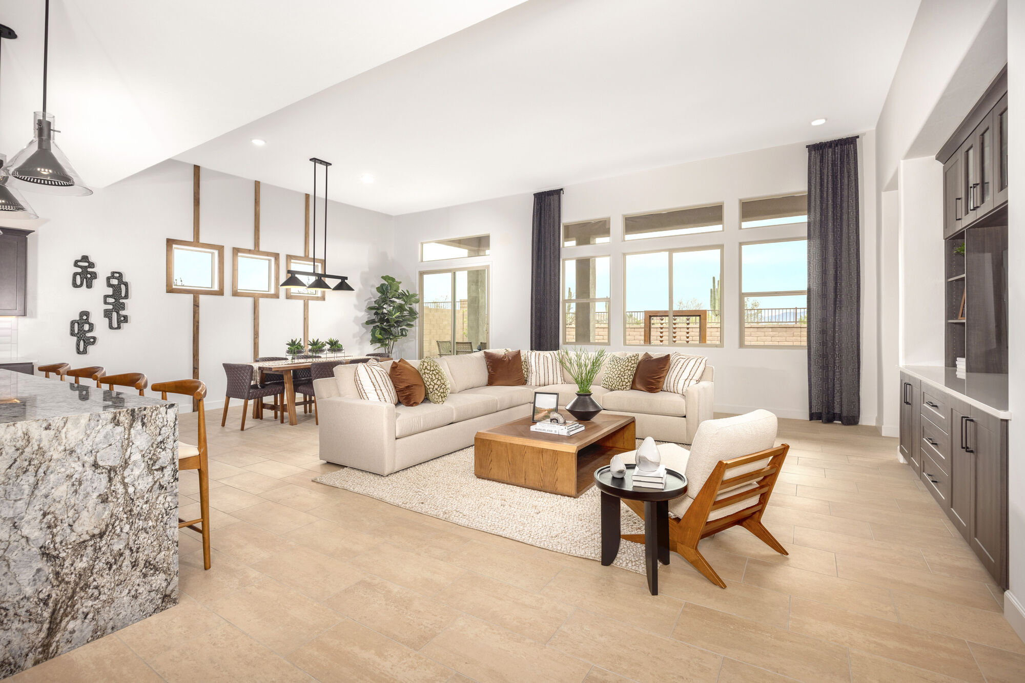 Greatroom with curtains, pendant light, window, painting, rug, dark wood cabinets and tile flooring