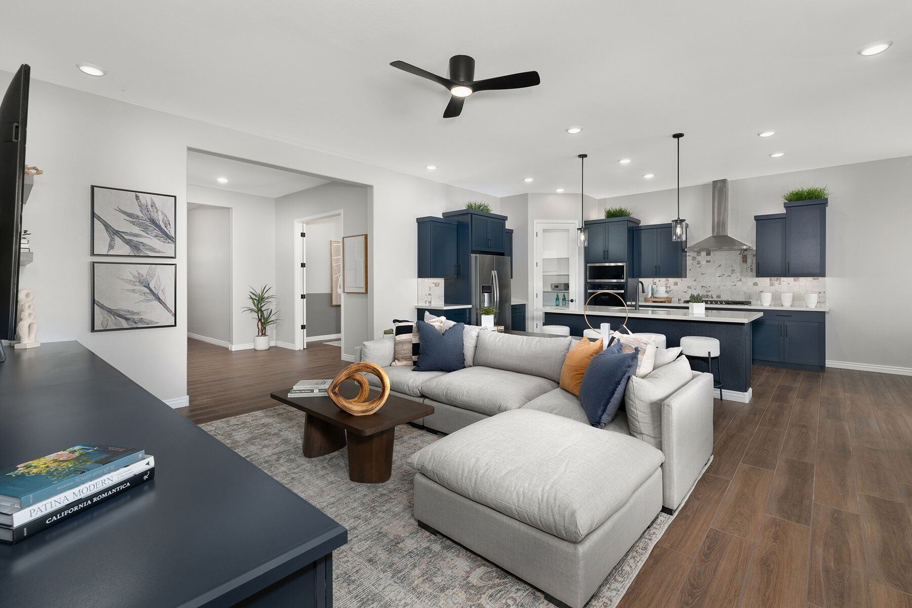 Greatroom with painting, pendant light, refrigerator and wood flooring