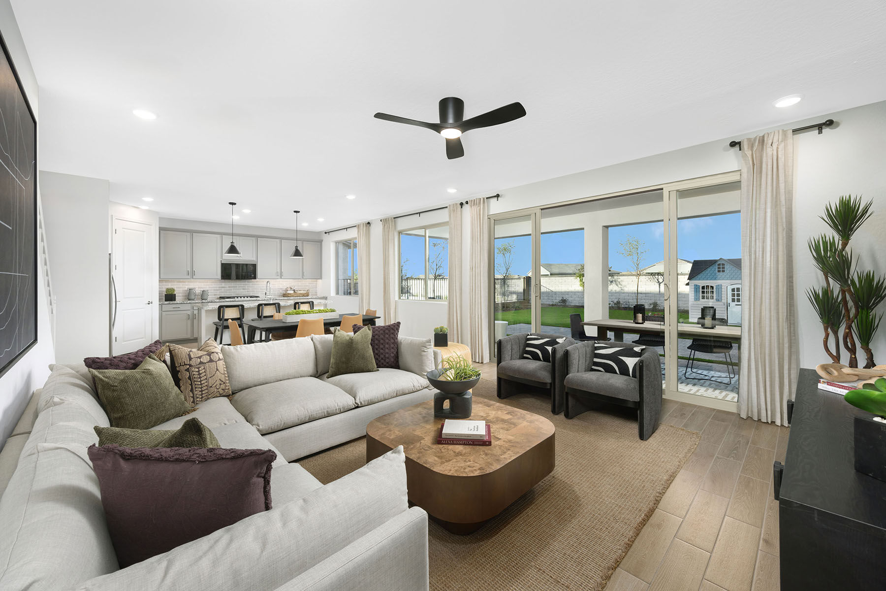 Greatroom with curtains, rug, window, door, pendant light and white cabinets