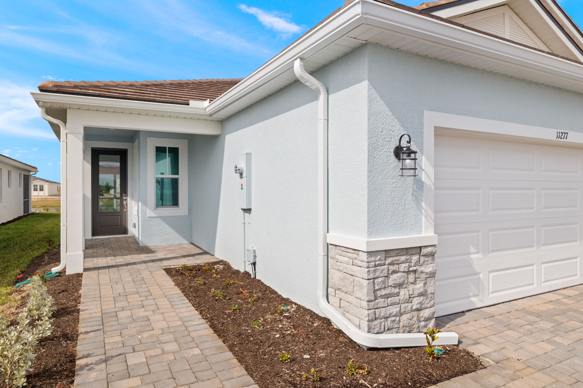 Villa, Auburn, 2 bedroom, 2 bath, open concept, shaker style cabinets, durable quartz countertops, walk-in pantry, stainless steel appliances, refrigerator, breakfast bar, kitchen island, laundry room, oversized sliders to lanai, owners suite, en suite with walk-in closet, oversized shower with glass wall, linen closet, dual sink raised vanity, 2-car garage, bath with glass enclosed shower, front porch
