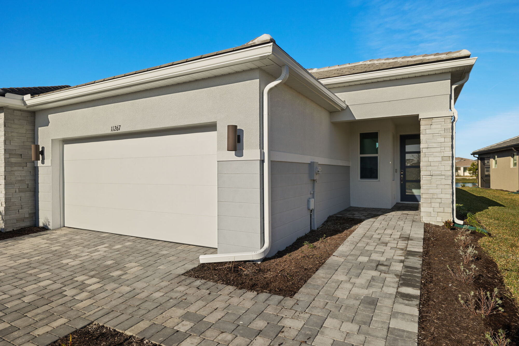 villa, 2 bedroom, 2 bathrooms, open concept, shaker style cabinets, quartz countertops, stainless steel appliances, refrigerator, pantry, breakfast bar on kitchen island, oversized glass sliders, covered lanai, screened lanai, pond view, owners bath with dual sink raised vanity, shower with glass wall, walk-in closet, bath with tub/shower combo, laundry room, tray ceiling, LED lighting, pavers