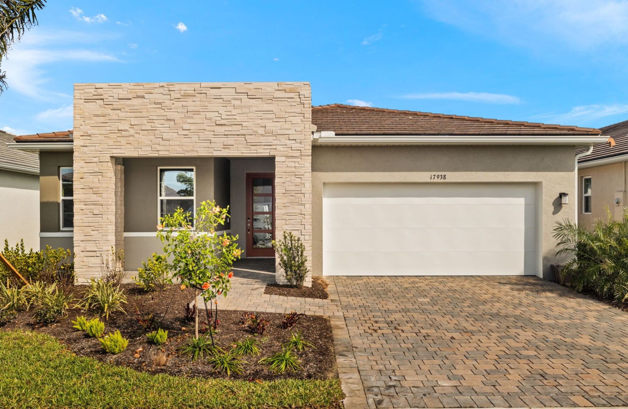 Modern exterior, single family home, open concept, glass sliding doors, light colored cabinets and countertops, 3 or 4 bedrooms, stainless steel appliances, lake view, tan and brown wood style plank tile flooring