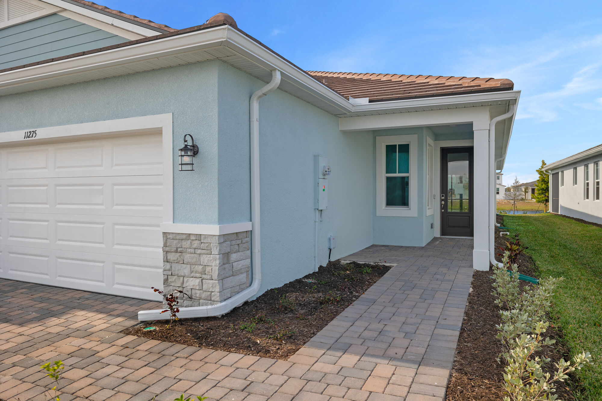 villa, 2 bedrooms, 2 baths, 2-car garage, luxury vinyl plank flooring, oversized glass sliders, open kitchen with white shaker style cabinets, stainless steel appliances, kitchen island, walk-in closet, tray ceiling, pond view, screened lanai 